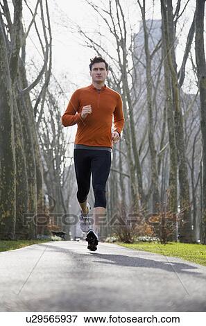 Stock Photo - USA, New York City, man jogging in park. Fotosearch