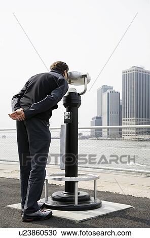 USA, New York City, Manhattan, man looking at skyline through telescope View Large Photo Image Stock Image - USA, New York City, Manhattan, man looking at skyline through telescope. Fotosearch
