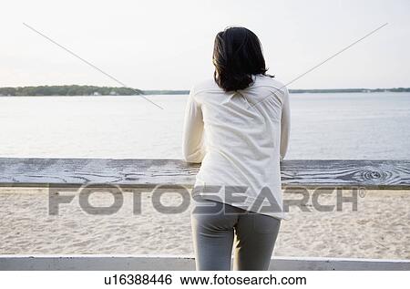 USA, New York State, Long Island, woman leaning against rail fence and looking at lake View Large Photo Image Stock Photograph - USA, New York State, Long Island, woman leaning against rail fence and looking at lake. Fotosearch