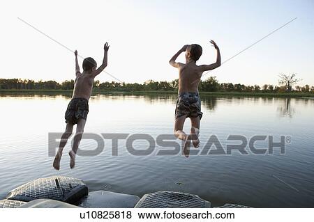 USA, Texas, Texarkana, Two boys (8-9) jumping into lake View Large Photo Image Stock Photo - USA, Texas, Texarkana, Two boys (8-9) jumping into lake. Fotosearch