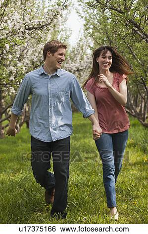 USA, Utah, Provo, Young couple walking through orchard View Large Photo Image Stock Photograph - USA, Utah, Provo, Young couple walking through orchard. Fotosearch