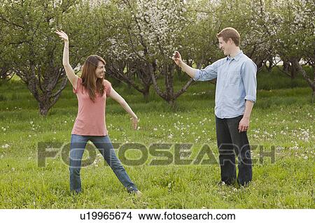 USA, Utah, Provo, Young man photographing young woman in orchard View Large Photo Image Picture - USA, Utah, Provo, Young man photographing young woman in orchard. Fotosearch