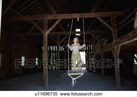 USA, Vermont, Dorset, Woman on swing in barn View Large Photo Image Stock Photography - USA, Vermont, Dorset, Woman on swing in barn. Fotosearch