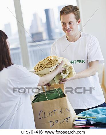 Stock Photograph - Volunteers organizing clothing drive. Fotosearch