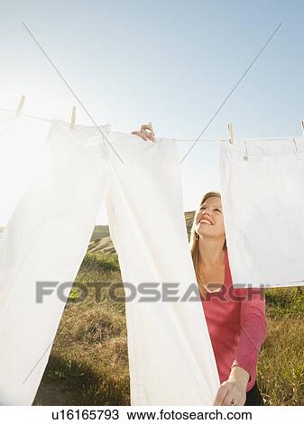 Woman hanging laundry on clothesline View Large Photo Image Stock Image - Woman hanging laundry on clothesline . Fotosearch