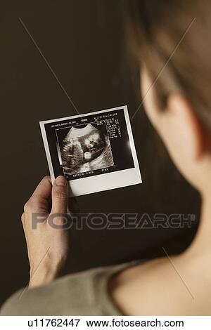 Woman holding ultrasonograph photo of baby View Large Photo Image Stock Photo - Woman holding ultrasonograph photo of baby. Fotosearch