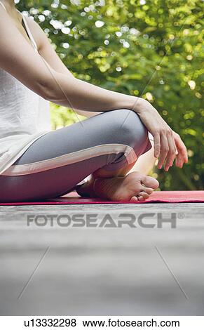 Woman sitting in yoga position in garden View Large Photo Image Stock Photo - Woman sitting in yoga position in garden. Fotosearch