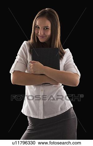 Stock Image - Young attractive businesswoman holding file. Fotosearch