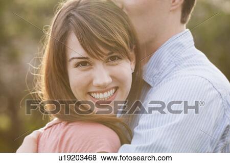 Young couple embracing outdoors View Large Photo Image Stock Photo - Young couple embracing outdoors. Fotosearch
