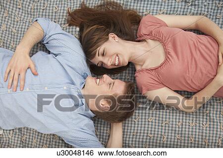 Stock Photograph - Young couple lying on blanket. Fotosearch