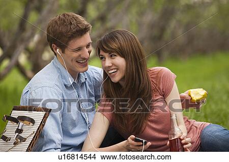 Young couple with mp3 player in orchard View Large Photo Image Picture - Young couple with mp3 player in orchard. Fotosearch