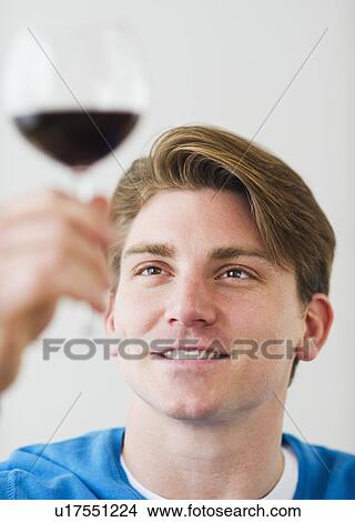 Picture - Young man examining red wine. Fotosearch