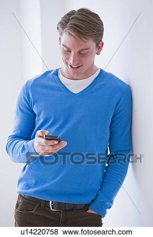 Stock Photo - Young man text messaging. Fotosearch