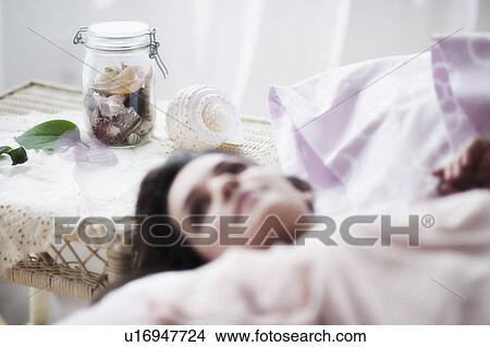 Picture - Young woman daydreaming in bed. Fotosearch