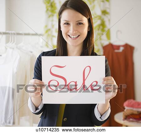 Stock Photography - Young woman holding "sale" sign. Fotosearch