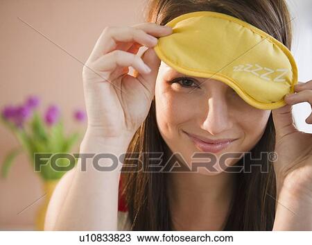 Young woman holding yellow sleep mask View Large Photo Image Stock Image - Young woman holding yellow sleep mask. Fotosearch