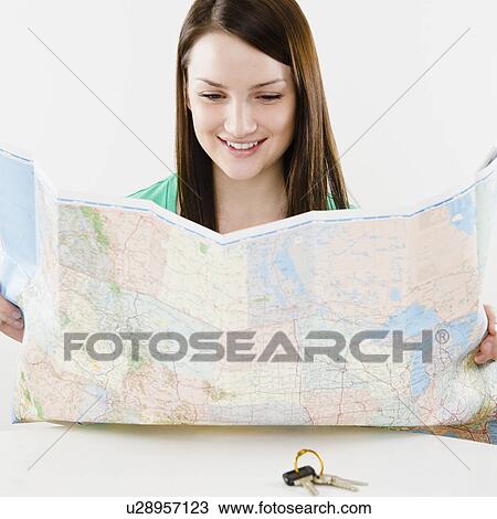 Young woman looking at map, car keys in foreground View Large Photo Image Stock Image - Young woman looking at map, car keys in foreground. Fotosearch