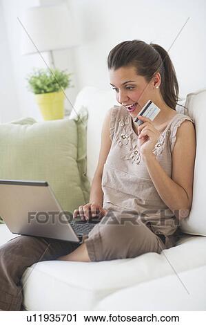 Stock Image - Young woman online shopping . Fotosearch