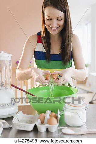Young woman preparing food in kitchen View Large Photo Image Stock Photo - Young woman preparing food in kitchen. Fotosearch