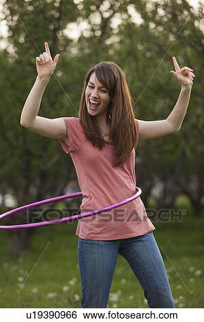 Young woman using plastic hoop in orchard View Large Photo Image Stock Photograph - Young woman using plastic hoop in orchard. Fotosearch