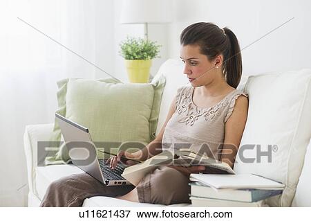 Stock Photo - Young woman working from home, using laptop. Fotosearch