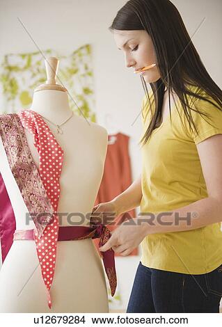 Picture - Young woman working with dressmakers model. Fotosearch