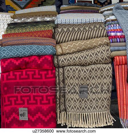 Stock Image - Blankets for sale at a market stall in Pisac, Sacred Valley, Cusco Region, Peru. Fotosearch