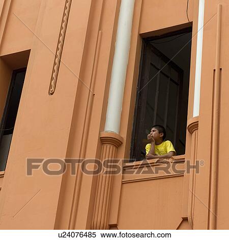 Stock Photography - Boy looking through the window of a building in Historic Centre of Lima, Lima, Peru. Fotosearch