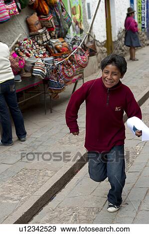 Stock Photo - Boy running at Sunday market, Pisac, Cuzco, Peru. Fotosearch