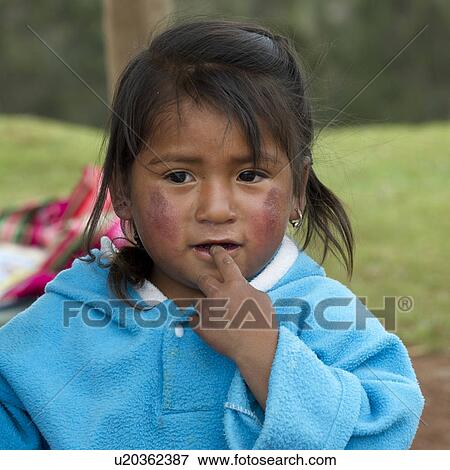 Stock Photo - Close-up of a girl with finger in her mouth, Sacred Valley, Cusco Region, Peru. Fotosearch