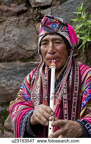 Stock Photo - Close-up of a senior woman playing a flute, Pisac, Sacred Valley, Cusco Region, Peru. Fotosearch