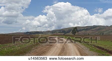 Stock Image - Dirt road passing through an agricultural field, Sacred Valley, Cusco Region, Peru. Fotosearch