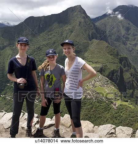 Friends standing together with The Lost City of The Incas in the background, Machu Picchu, Cusco Region, Peru View Large Photo Image Picture - Friends standing together with The Lost City of The Incas in the background, Machu Picchu, Cusco Region, Peru. Fotosearch
