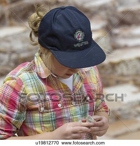 Stock Image - Girl holding a salt stone, Maras, Salinas, Sacred Valley, Cusco Region, Peru. Fotosearch