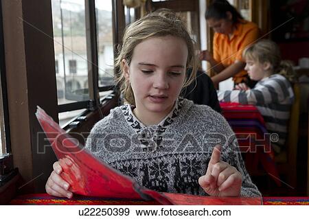 Girl reading menu in a restaurant, Cuzco, Peru View Large Photo Image Stock Photo - Girl reading menu in a restaurant, Cuzco, Peru. Fotosearch