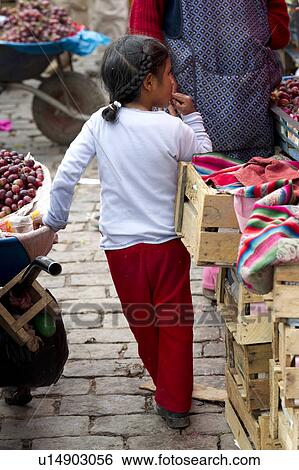 Stock Photograph - Girl standing at a market, Cuzco, Peru. Fotosearch