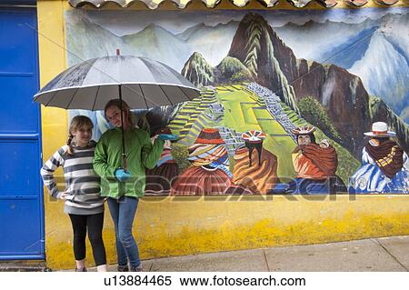 Girls sheltering under an umbrella in front of a mural of Machu Picchu, Cusco Region, Peru View Large Photo Image Stock Photography - Girls sheltering under an umbrella in front of a mural of Machu Picchu, Cusco Region, Peru. Fotosearch