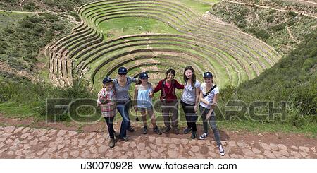 Stock Photo - High angle view of people with Incan agricultural terraces in the background, Moray, Machu Picchu, Cusco Region, Peru. Fotosearch