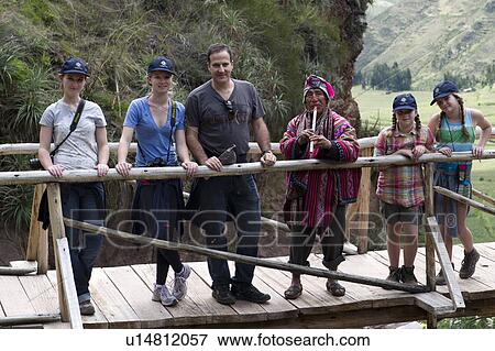 Stock Photo - Man with his family on a footbridge at Archaeological Park of Pisac, Pisac, Sacred Valley, Cusco Region, Peru. Fotosearch
