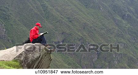 Person reading a book at the edge of a rock at The Lost City of The Incas, Machu Picchu, Cusco Region, Peru View Large Photo Image Stock Photo - Person reading a book at the edge of a rock at The Lost City of The Incas, Machu Picchu, Cusco Region, Peru. Fotosearch