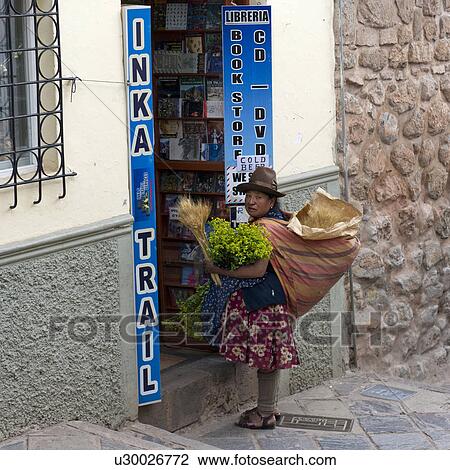Stock Image - Peruvian woman selling plants at a store, Cuzco, Peru. Fotosearch