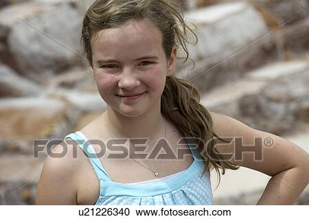 Stock Image - Portrait of a teenage girl at a salt mine, Maras, Salinas, Sacred Valley, Cusco Region, Peru. Fotosearch