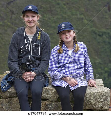 Stock Image - Portrait of a woman with her sisters at The Lost City of The Incas, Machu Picchu, Cusco Region, Peru. Fotosearch