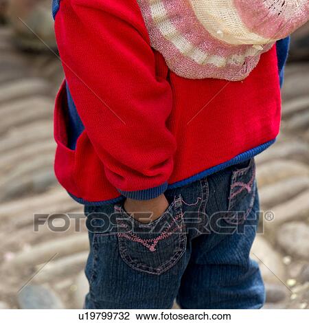 Stock Image - Rear view of a girl in Sunday market, Pisac, Sacred Valley, Cusco Region, Peru. Fotosearch