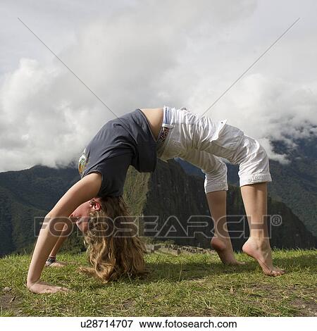 Teenage girl doing wheel pose with valley in the background, The Lost City of The Incas, Machu Picchu, Cusco Region, Peru View Large Photo Image Stock Photo - Teenage girl doing wheel pose with valley in the background, The Lost City of The Incas, Machu Picchu, Cusco Region, Peru. Fotosearch