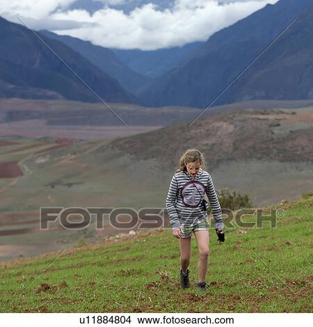 Teenage girl walking in a field with Sacred Valley in the background, Cusco Region, Peru View Large Photo Image Picture - Teenage girl walking in a field with Sacred Valley in the background, Cusco Region, Peru. Fotosearch