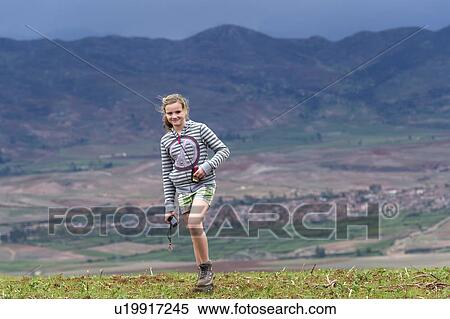 Stock Photography - Teenage girl walking in a field with Sacred Valley in the background, Cusco Region, Peru. Fotosearch