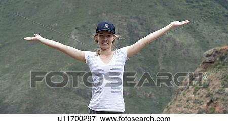 Teenage girl with her arm outstretched with Sacred Valley in the background, Cusco Region, Peru View Large Photo Image Stock Photo - Teenage girl with her arm outstretched with Sacred Valley in the background, Cusco Region, Peru. Fotosearch