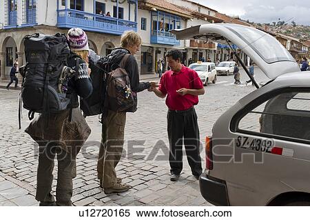 Stock Photography - Tourists talking to a taxi driver, Plaza de Armas, Cuzco, Peru. Fotosearch