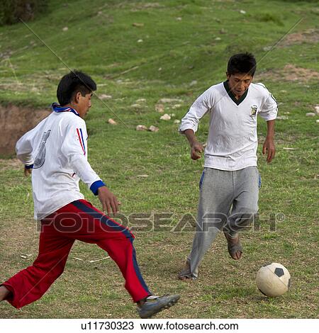 Stock Image - Two men playing soccer, Sacred Valley, Cusco Region, Peru. Fotosearch